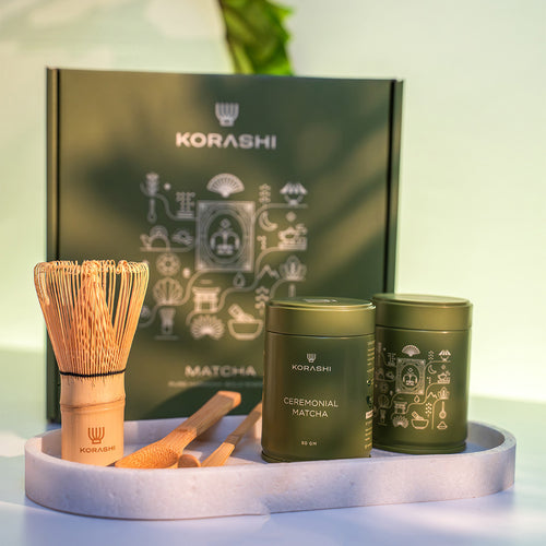 Korashi matcha tea set with two green containers, a whisk, and a scoop on a white tray.